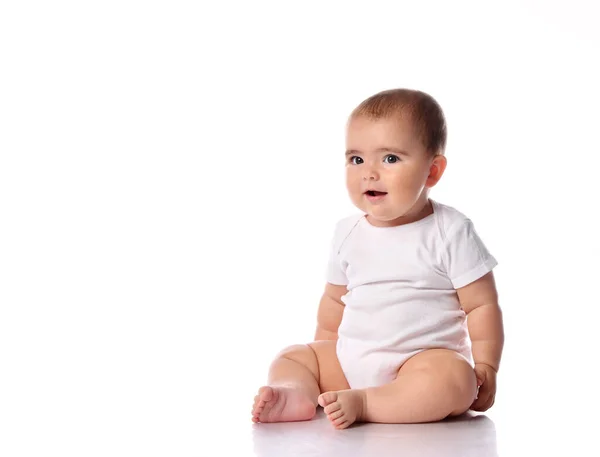 Surprised baby kid sitting on white studio floor — Stock Photo, Image
