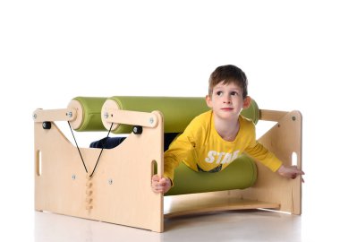 Gülümseyen küçük çocuk, egzersiz seti düzensizliğini gösteriyor. Beyazlara izole edilmiş, kopyalama alanı.