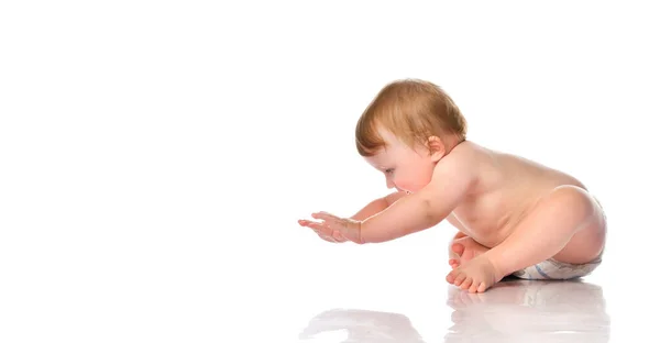 Bébé garçon tire ses mains pour se tenir à quatre pattes sur un fond blanc. — Photo
