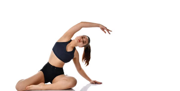 Mujer joven atlética practicando ejercicios de yoga, aislada sobre fondo blanco. — Foto de Stock