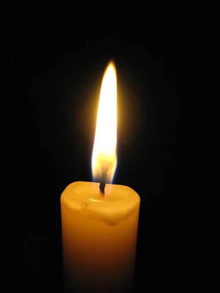 Yellow candle light on the dark background. Cozy light. — Stock Photo, Image