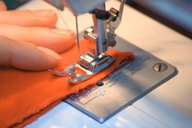 Kırmızı iplik dikiş makinesi sıkışmış. Elbise eller tarafından dikmek. Yeni yıl geliyor. Yeni yıl ve Noel için dikiş. 