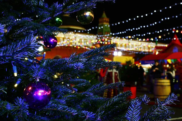 Színes balled szabadtéri karácsonyfa. Ünneplése a ember háttér megvilágítás. Szünet igemód — Stock Fotó