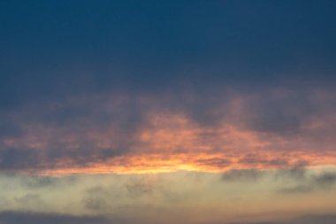 Kılçık bulutlara. Ateşli kırmızı yükselen Güneş bulutların arkasında. Bunun başlık