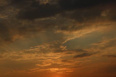 Kılçık bulutlara. Ateşli kırmızı yükselen Güneş bulutların arkasında. Bunun başlık
