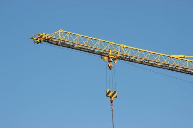 İnşaat alanında mavi gökyüzü arka plan üzerinde sarı vinç ile. İnşaat, inşaat işi, ağır yük kaldırma
