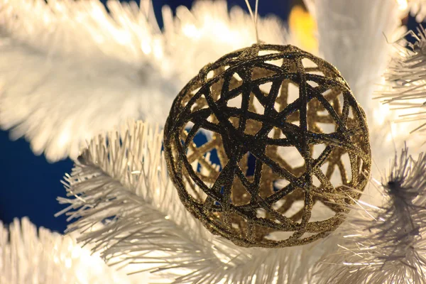 編みこみの光沢のあるゴールドのボールは トウヒの白でハングします クリスマス ツリーの装飾 ボールの反射で虹色に輝く光 正月気分 スクリーン セーバー ポストカードの背景 — ストック写真