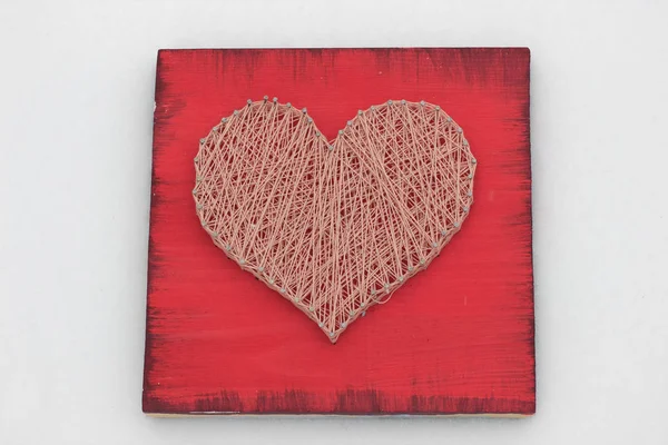 panels of thread and nails, heart on red background. string art. gift or decoration for February 14 and March 8. with love