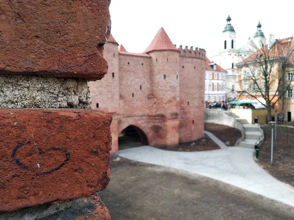 Le coeur est sur le mur de briques, aimer les vieilles villes. le château est proche des bâtiments modernes. centre historique de la ville. toucher à l'histoire du monde . — Photo