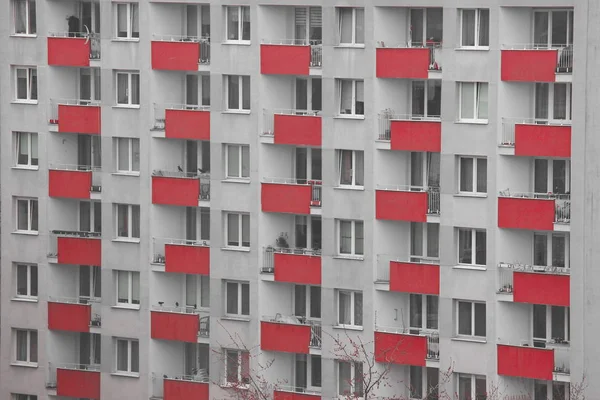 Fenster eines Mehrfamilienhauses, symmetrische Rahmen in einem grauen Haus. viele Zimmer in einem Haus. moderner Wohnungsbau. — Stockfoto