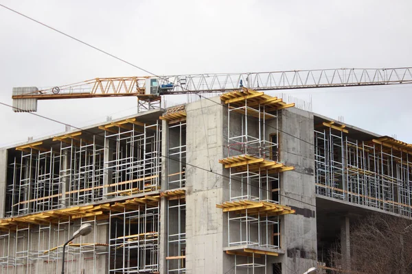 La destrucción del antiguo edificio, la reconstrucción, los cambios estructurales. construcción, obras de grúa de gran altura en el sitio. el edificio está hecho de ladrillo, azulejos en las paredes. instalación, montaje, imp —  Fotos de Stock