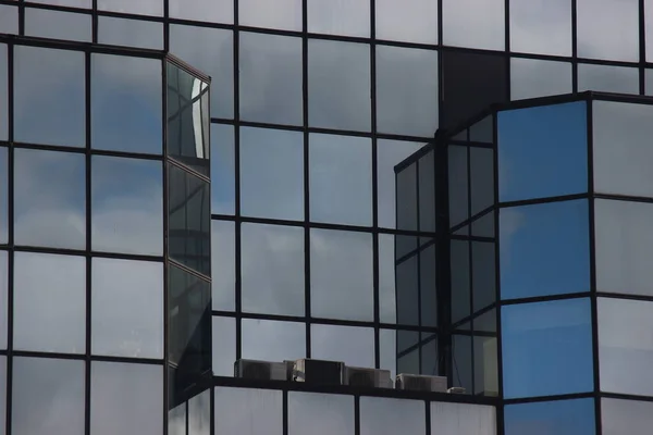 Fenêtres d'une maison moderne. gratte-ciel en verre dans la ville, immeuble de bureaux à la mode avec des fenêtres du sol au plafond. chambres lumineuses et construction moderne. nouvelles possibilités d'incarnation dans la réalité . — Photo