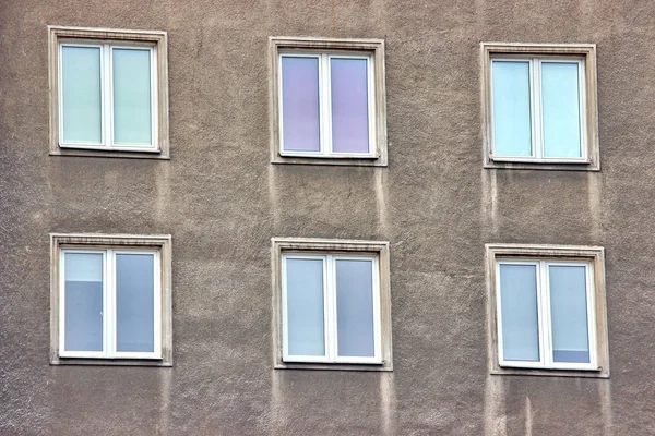 Białe, plastikowe okna, budynek, ramki symetryczne szary dom mieszkania. z wielu pokoi w jednym domu. Budowa nowoczesnego budownictwa mieszkaniowego. stary budynek — Zdjęcie stockowe