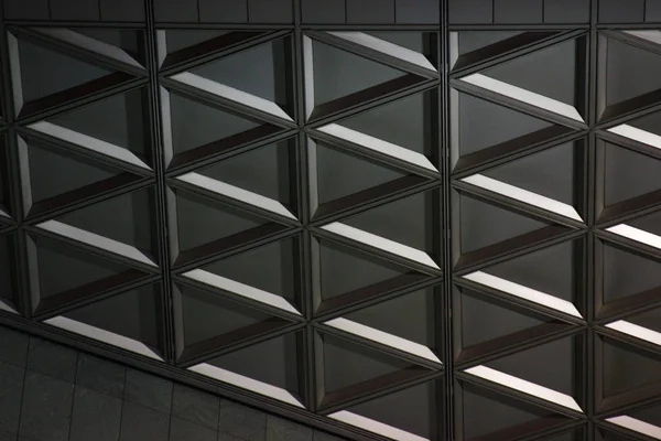 Geometrie aus Beton und Glas. moderne Bauweise, Schönheit im Detail. Dreiecke Hintergrund. Strenge der Linien in grauer Farbe — Stockfoto