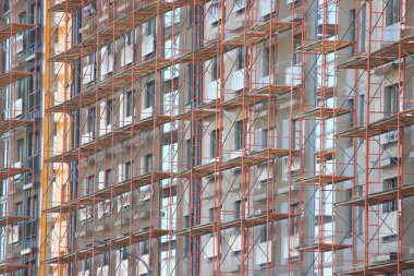 evin dış dekorasyon için iskele, çok katlı ve apartmanların modern inşaat. şehirde insanların yaşamları için somut yapılar. evler inşa. ritmik, tekrarlayan ge