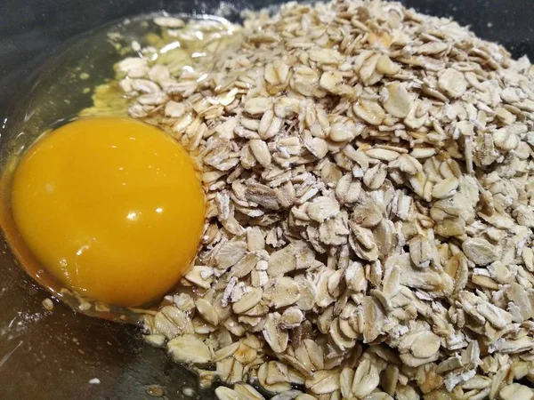 Eier und Haferflocken in einem transparenten Teller, gesundes Kochen. Pfannkuchen, Kekse oder Haferschnitzel. eine abwechslungsreiche gesunde Ernährung für die ganze Familie. — Stockfoto