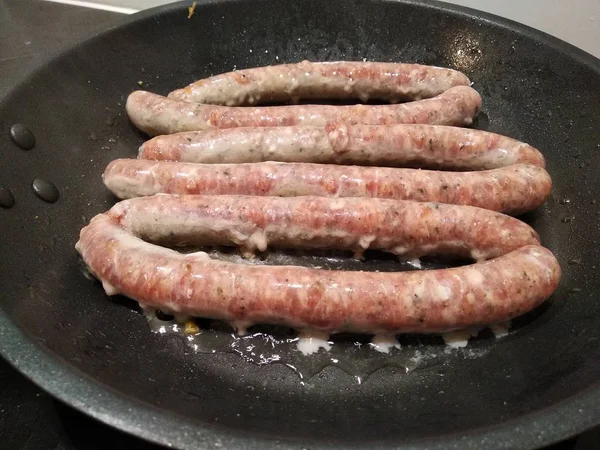 O dedo empurrou a linguiça. comida de carne rústica caseira em uma concha natural. Churrasco, para cozinhar na grelha, skorovoda ou fogo — Fotografia de Stock