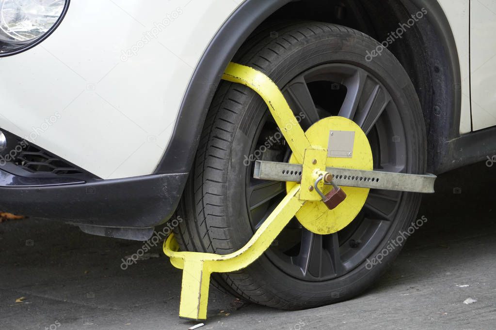 locking device on the wheel of a car, parking violation in the city, city parking, wheel lock