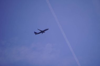 Krakow, Polonya - 28 Temmuz: Ryanair yolcu uçağı mavi gökyüzünde yüksek uçan. Gökyüzünde jet yakıtı izi. açık beyaz bulutlar. tatil veya iş gezisi mal ve insanların taşınması