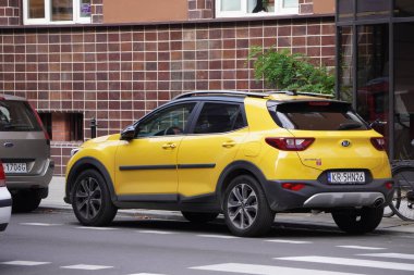 Krakow, Polonya- 07.30.2019: Kırmızı tuğlalı eve park, sarı ve gri arabalar yola paralel park edildi. beyaz şerit işaretleri ve geçiş pürüzsüz ve evde arsa