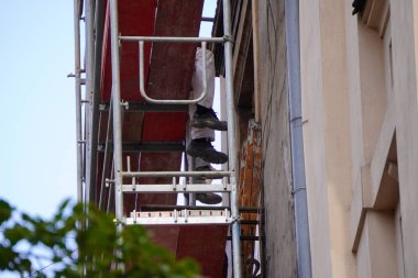 evde iskele, işçilerin ayakları, çalışırken dinlenme, kırmak. binanın yeniden inşası veya onarımı. bina çitleri