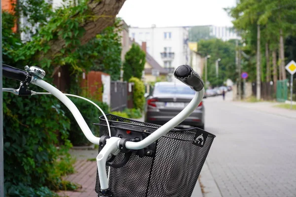 Blue city bike with a basket for food or things on the street with low houses, ease of movement around the city. eco-friendly mode of transport.