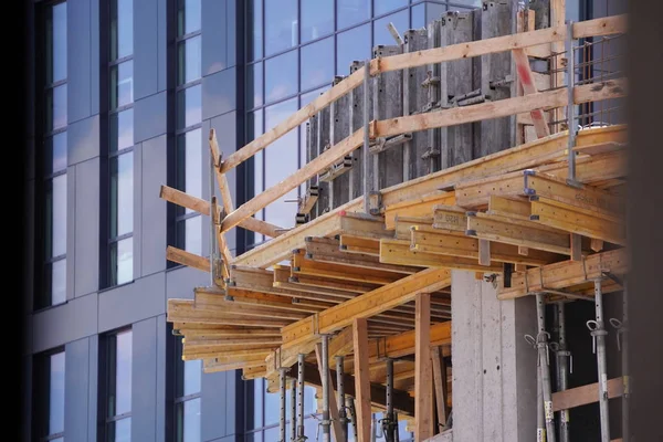 Construcción de un nuevo edificio de metal-hormigón y ladrillo en el fondo de la casa construida. tecnologías modernas en la construcción y reparación —  Fotos de Stock