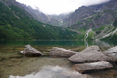 Berrak mavi-yeşil su ile görkemli dağ gölü. dağların muhteşem manzarası. Morskie Oko dağ gölü manzarası, Milli Park Tatra Dağları, Polonya. doğal manzara duvar kağıdı