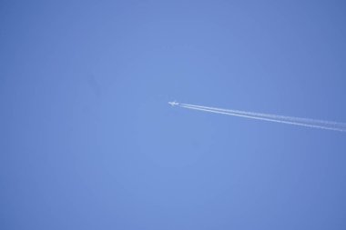 bulutlar olmadan mavi gökyüzüne karşı uçağın beyaz iz. uçakta yakıt yanma, emisyon. seyahat konsepti