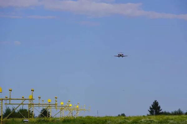 飞机在阳光明媚的夏日接近跑道，与蓝天飞去，降低卸货的高度和速度，降低信号灯的方向 — 图库照片