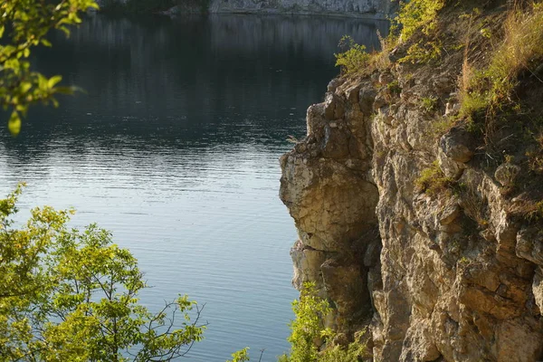 kayalık dağlar arasında göl, turkuaz berrak su, vahşi doğa, su da güneşin yansıması, berrak suda dağların yansıması