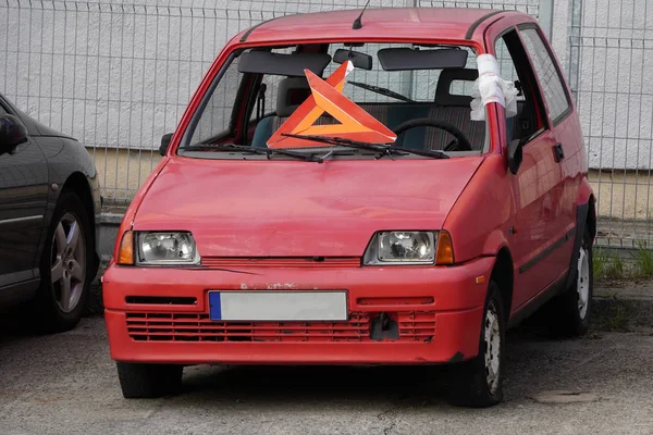 Cassé vieille couleur de corail de voiture est dans la cour. panneau d'arrêt d'urgence au lieu du pare-brise, entretoise avant enveloppée de ruban adhésif — Photo