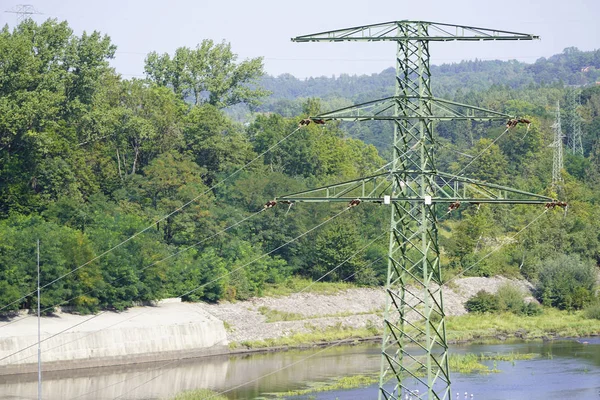 Costruzione di pali di trasmissione del ferro sullo sfondo della foresta, la trasmissione di energia elettrica a città e villaggi. il prodotto della centrale idroelettrica . — Foto Stock