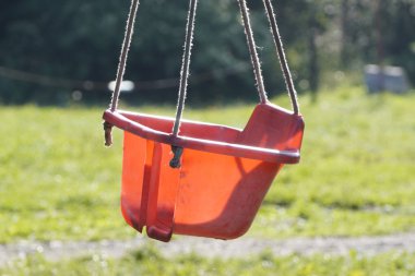 Güneşli bir günde ağaca asılı kırmızı bebek plastik salıncak. küçük çocuklar ve ebeveynleri, van yaşam, çadır ve kamp larda dinlenme için ülkede dinlenme