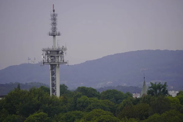 Torre de rádio TV na cidade, cidade moderna verde. transmissão de sinais para diferentes partes do país — Fotografia de Stock