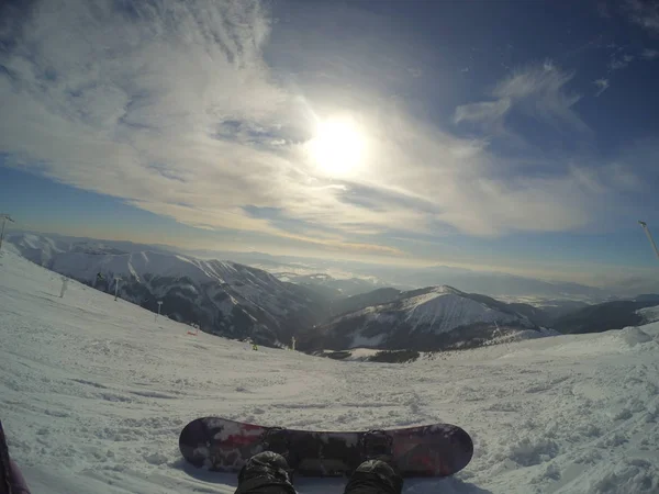 Inverno dia claro nas montanhas, o sol nas nuvens nebulosas, a vista para a distância, a foto da câmera esportiva. terreno montanhoso, estância de esqui de montanha — Fotografia de Stock
