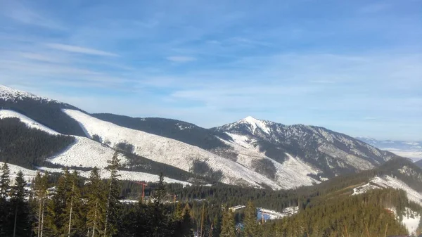 Inverno dia claro nas montanhas, o sol nas nuvens nebulosas, a vista para a distância, a foto da câmera esportiva. terreno montanhoso, estância de esqui de montanha — Fotografia de Stock
