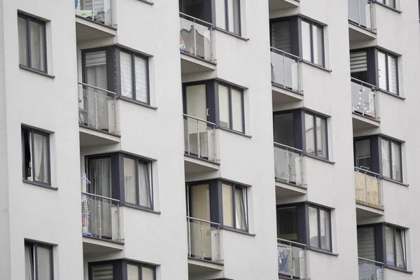 Betondan yapılmış çok katlı bir binanın cam balkonları. Büyük şehirlerdeki insanlar için barınak. Bir apartman kompleksinin Fransız parlaklığı.