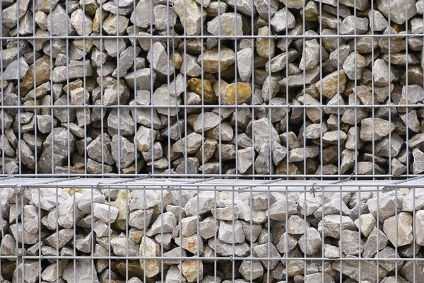 stones in an iron net. The fence or bench is made of gabions. de