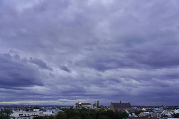 roofs of houses and a Church at sunset, the dark sky with clouds before a thunderstorm. old town top view. the observation deck on the roof