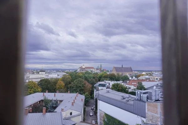 roofs of houses and a Church at sunset, the dark sky with clouds before a thunderstorm. old town top view. the observation deck on the roof