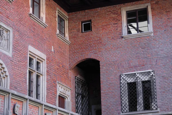 Viejo edificio de ladrillo rojo, ventanas y puertas decoradas, balcón al patio , — Foto de Stock