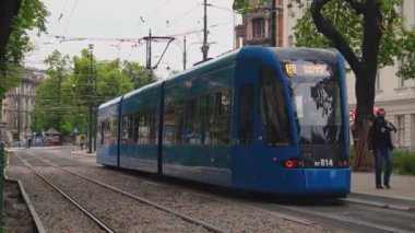 Modern mavi tramvay bombacısı şehirden geçiyor. Toplu taşımanın modernizasyonu. Çevre dostu ulaşım aracı. Tramvay tasarımında yeni teknolojiler. Krakow, Polonya 18.05.2020