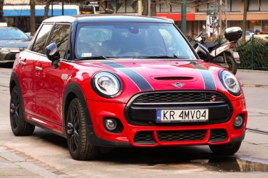 Şehirde kırmızı bir Mini Cooper S yolda duruyor. Küçük şehir hatchback 'i, şık bir İngiliz arabası. Şehre park ediyorum. Krakow, Polonya 19.02.2020