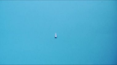 Kağıt uçak mavi arka planda görünür. Kağıttan bir şeyleri katlama sanatı. Hareketi durdur. HD video