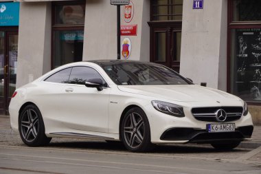 Krakow, Polonya 19.02.2020: Yeni lüks spor araba Mercedes-benz C-sınıfı AMG coupe W205 beyaz araba, şehir caddesinde park yeri.