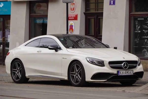 Krakow, Polonya 19.02.2020: Yeni lüks spor araba Mercedes-benz C-sınıfı AMG coupe W205 beyaz araba, şehir caddesinde park yeri.