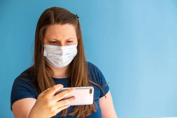 Europäische Bloggerin Medizinischer Maske Auf Blauem Hintergrund Mit Handy Der — Stockfoto