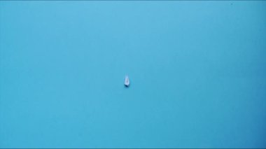 Kağıt uçak mavi arka planda görünür. Kağıttan bir şeyleri katlama sanatı. Hareketi durdur. HD video