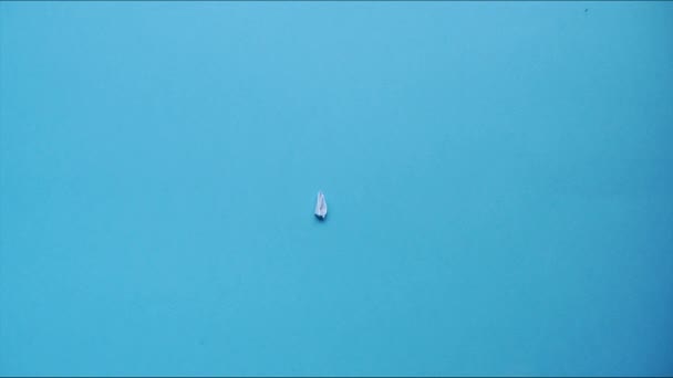 紙飛行機は青い背景に現れます 紙から物事を折る芸術 動くな Hdビデオ — ストック動画
